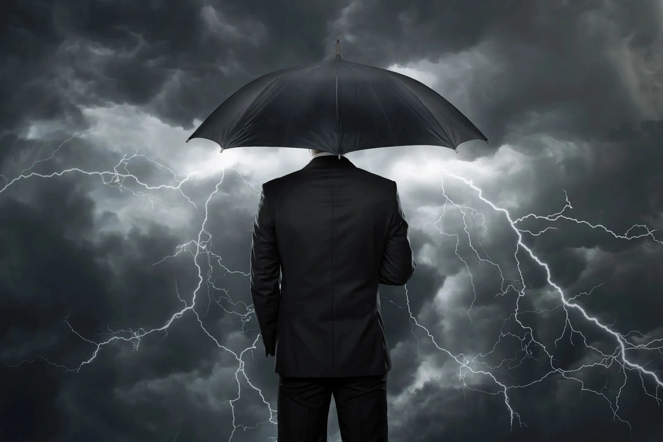 Man in suit with umbrella amid lightning